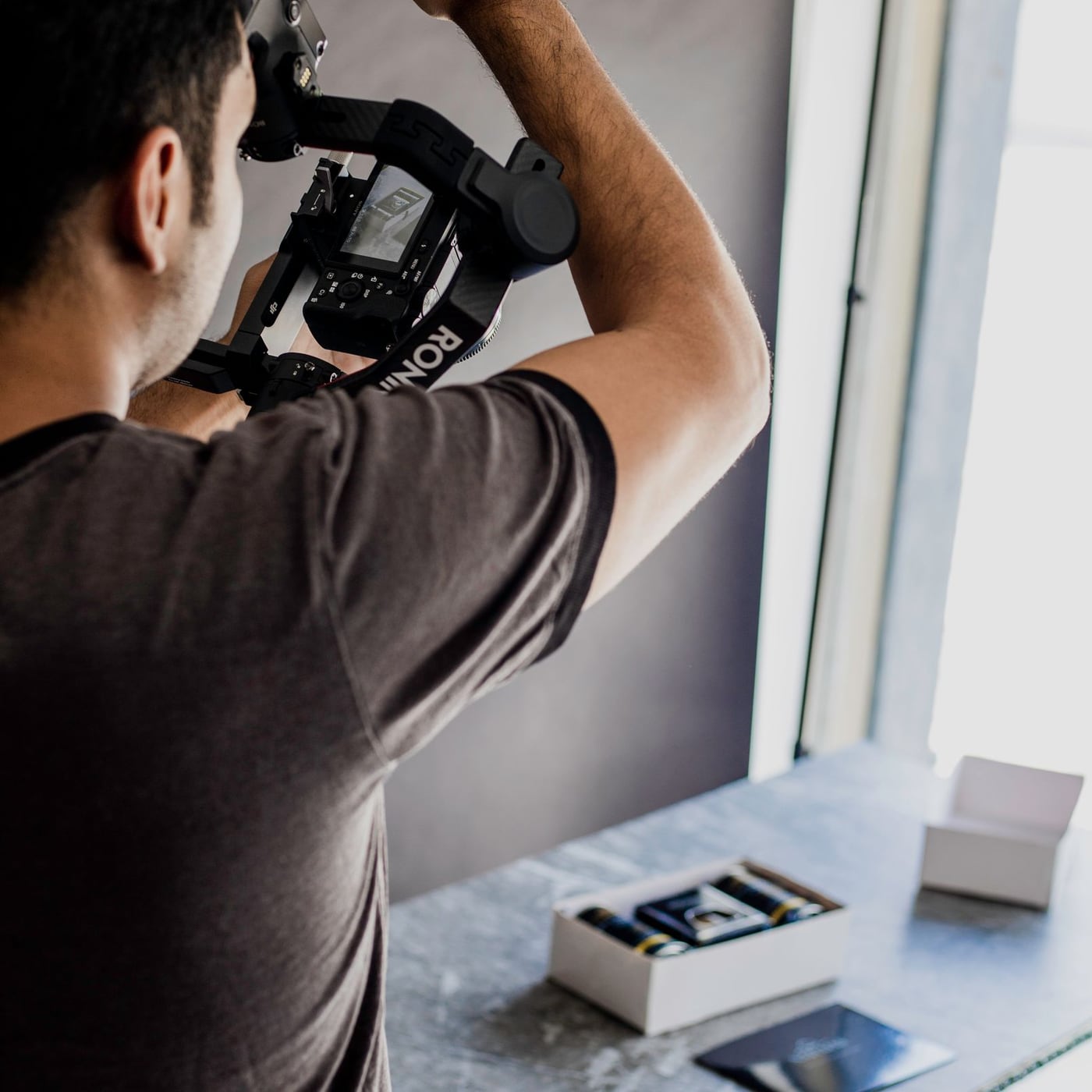 Fotografía profesional de productos cosméticos con iluminación de precisión sobre superficie reflectante.