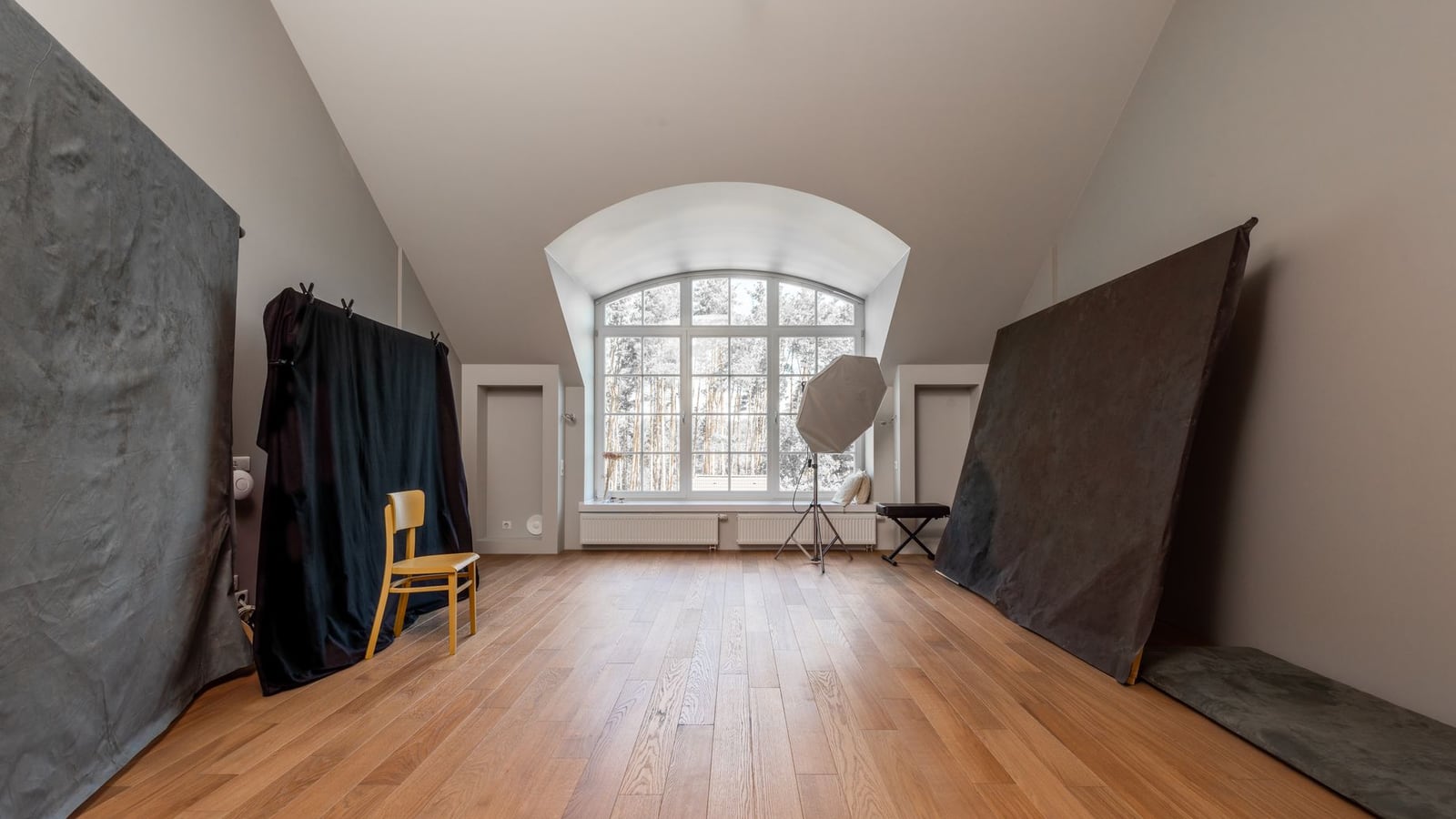 Interior de un estudio fotográfico moderno en Madrid con ciclorama blanco y equipo de iluminación profesional.